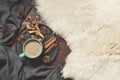 Hygge still life with hot cup of black coffee, anise, warm scarf on furskin and wooden board. Copy space. Top view. Royalty Free Stock Photo