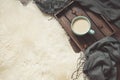 Hygge still life with hot cup of black coffee, anise, warm scarf on furskin and wooden board. Copy space. Top view. Royalty Free Stock Photo