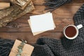 Hygge style flatlay composition with book, cup of coffee, fashion knitted scarf, firewood on wooden background. Flat lay, top view Royalty Free Stock Photo