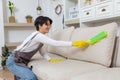 Hygiene and cleanliness in the living room. A Cleaning lady with gloves wipes dust from furniture with a cloth Royalty Free Stock Photo