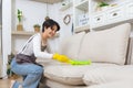 Hygiene and cleanliness in the living room. A Cleaning lady with gloves wipes dust from furniture with a cloth Royalty Free Stock Photo