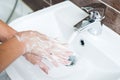 Hygiene concept. Washing hands with soap under the faucet with water