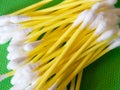 Hygiene Essentials. Yellow cotton swabs on a green surface Royalty Free Stock Photo