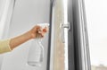 Hands cleaning window handle with detergent