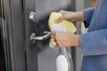 Hand cleaning door handle with detergent and rag Royalty Free Stock Photo