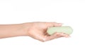 Hygiene and health care topic: a woman's hand holding a green bar of soap isolated on white background in studio Royalty Free Stock Photo