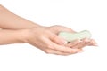Hygiene and health care topic: a woman's hand holding a green bar of soap isolated on white background in studio Royalty Free Stock Photo