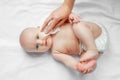 Hygiene - young mom wiping the baby skin body and face with wet wipes carefully on white background. concept cleaning wipe, pure, Royalty Free Stock Photo