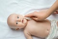 Hygiene - young mom wiping the baby skin body and leg with wet wipes carefully on white background. Mom and her Child. Beautiful