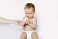 Hygiene - young momy wiping the baby skin with wet wipes. Little baby girl in diaper sitting and taking the wet wipe Royalty Free Stock Photo