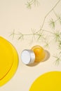 Hygienic container for lip balms, lying on a natural beige background. Conceptual composition, yellow color, natural green. Royalty Free Stock Photo