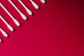 Hygienic, cotton buds on a red background. The concept of hygiene, cleanliness
