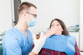 Hygienist with scared patient showing syringe needle