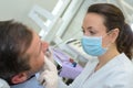 Hygienist working on man`s teeth