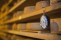 Hygrometer or water density scale hanging in a room with cheese rolls on wooden shelves Royalty Free Stock Photo