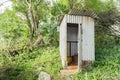 A Zinc House Pit Latrine In The Woods With Hylocereus Cactus On The Roof