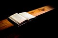 Hymnbook lies open on a church bench and is illuminate with a soft light