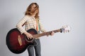 Hyped girl playing full size guitar. Shaking her head, enjoying herself. Royalty Free Stock Photo