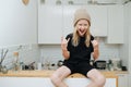 Hyped pumped boy sitting on a high table, showing rock'n roll gesture Royalty Free Stock Photo