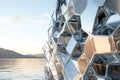 A hyper-modern architectural facade designed entirely from tessellating hexagonal glass panels. The