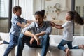 Hyperactive african children want to play with exhausted annoyed father