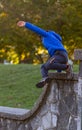 A hyperactive kid is jumping off a high wall as he is running away. Royalty Free Stock Photo