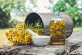 Hypericum - St Johns wort flowers, oil or infusion bottle, mortar and big vintage metal mug of Hypericum flowers.