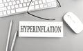 HYPERINFLATION text on paper with keyboard on grey background