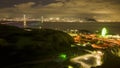 Hyperlapse: Busy highway onramp with lights from ferris wheel and distant bridge to city