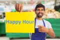 Hypermarket employee holding happy hour paper Royalty Free Stock Photo