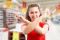 Hypermarket worker wishing good luck with crossed fingers and arms