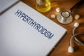 Hyperthyroidism written on book with tablets Royalty Free Stock Photo