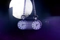 Hypnosis session. Vintage pocket watch with chain swinging against mystical sky on a full moon, motion effect Royalty Free Stock Photo