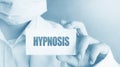 Hypnosis word written on a card in doctor& x27;s hand. Alternative therapy healthcare concept Royalty Free Stock Photo