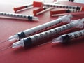 Hypodermic needles on red table Royalty Free Stock Photo