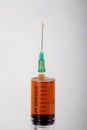 Syringe with needle and liquid drugs in the barrel in a studio with white backdrop