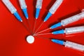 Hypodermic syringe. Syringes with blue needles on a red background. Medical Injectors. Royalty Free Stock Photo