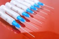 Hypodermic syringe. Syringes with blue needles on a red background. Medical Injectors. Royalty Free Stock Photo