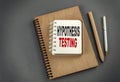 Hypothesis testing text on notebook with pen and pencil on grey background