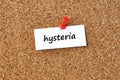 Hysteria. Word written on a piece of paper, cork board background