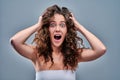 Hysterical woman expression with her hands on the head on a grey isolated background Royalty Free Stock Photo