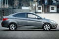 Hyundai accent in grey color, right side view.