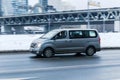Hyundai H-1 in the city street in motion. Side view of gray color large Hyundai Grand Starex MPV minivan on winter road
