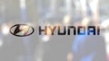 Hyundai Motor Company logo on a glass against blurred crowd on the steet. Editorial 3D rendering