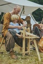 HÃÂ¸jbjerg, Denmark, August, 2022: Father carpenter teaching son at the viking festival