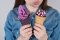 I adore candies concept. Cropped close up photo of satisfied excited dreamy cheerful lady choosing two objects to eat pink violet