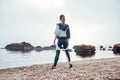 I adore living by the sea. Back view of confident disabled sporty woman in sportswear with prosthetic leg is standing on