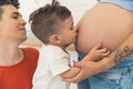 I already love you, baby, little kid kissing the belly of his pregnant mother Royalty Free Stock Photo