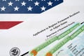 I-485 Application to register permanent residence or adjust status form and green card from dv-lottery lies on United States flag