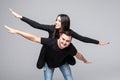 I believe I can fly. Love story of attractive, funny, cheerful couple - handsome man carrying his lover on back like plane, woman Royalty Free Stock Photo